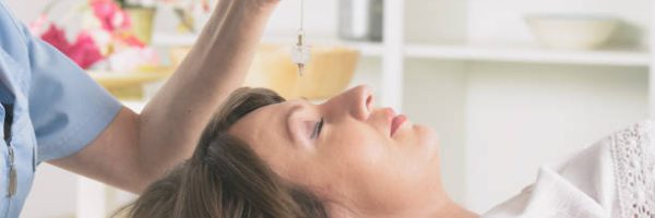 Alternative medicine therapist using pendulum to make a diagnosis