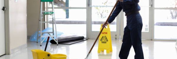 Senior adult Janitor keeps the floors cleaned and sanitized due to the virus.