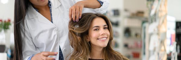 Beautiful Latin American woman at the hair salon talking to the hairdresser about a new hairstyle - beauty concepts