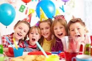 Group of adorable kids looking at camera at birthday party