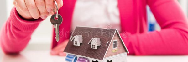 real-estate-agent-key-closeup-hand-offering-keys-new-house-to-buyer-holding-keyring-shallow-depth-field-53539459